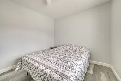 a bed in a white room with a blanket on it at Updated Hawthorne Apartment, 12 Mi to Walker Lake! in Hawthorne