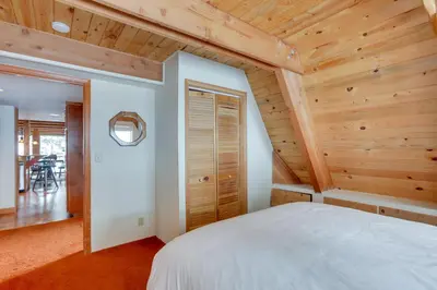 a bedroom with a white bed in a room with wooden ceilings at Donner Lake Views Rustic Truckee Cabin! in Truckee