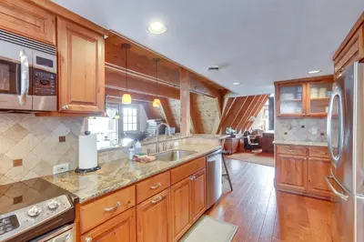 a kitchen with wooden cabinets and stainless steel appliances at Donner Lake Views Rustic Truckee Cabin! in Truckee