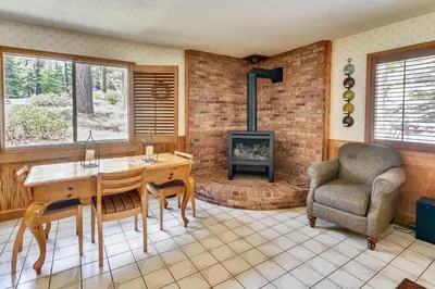 a living room with a table and a chair and a fireplace at Minutes To Heavenly, Private Covered Hot Tub in South Lake Tahoe