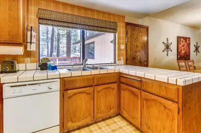 a kitchen with wooden cabinets and a sink and a window at Pet Friendly - Close To Heavenly, Steps To The River in South Lake Tahoe