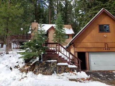 a house with a garage in the snow at Cabin Close To Hiking Trails And Ski Resorts in South Lake Tahoe