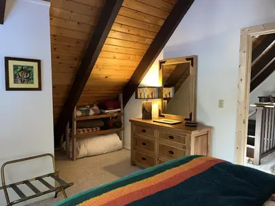 a bedroom with a bed and a dresser with a mirror at Cabin Close To Hiking Trails And Ski Resorts in South Lake Tahoe