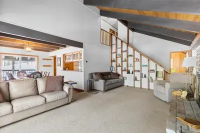 a living room with a couch and a stair case at Bigfoot Cabin in Camp Connell