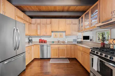 a kitchen with wooden cabinets and stainless steel appliances at Bigfoot Cabin in Camp Connell