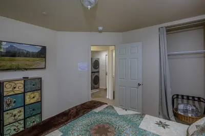 a bedroom with a bed and a television on the wall at Bear Paw Cabin new construction near Yosemite in Mariposa