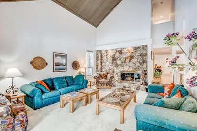 a living room with blue couches and a stone fireplace at Championship Pines in Incline Village