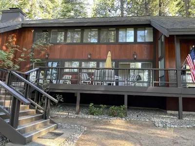 a house with a deck with chairs and a flag at Championship Pines in Incline Village