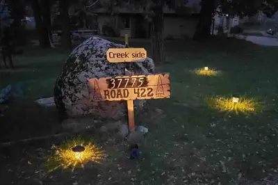 a street sign in a yard with a road sign at Forest Cabin by China Creek in Oakhurst