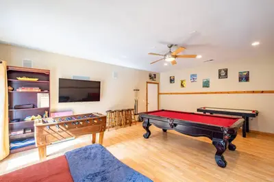 a living room with a pool table and a flat screen tv at Forest Cabin by China Creek in Oakhurst