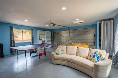 a living room with a ping pong table and a couch at Cherry Cottage 15 min from Yosemite South Entrance in Oakhurst