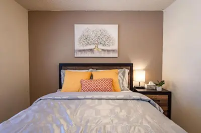 a bedroom with a bed with a painting on the wall at Cherry Cottage 15 min from Yosemite South Entrance in Oakhurst