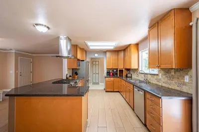 a large kitchen with wooden cabinets and black counter tops at Alpine 4 Bedroom Retreat with Hot tub and Pool table in Coarsegold