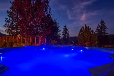 a blue hot tub in a yard at night at Alpine 4 Bedroom Retreat with Hot tub and Pool table in Coarsegold