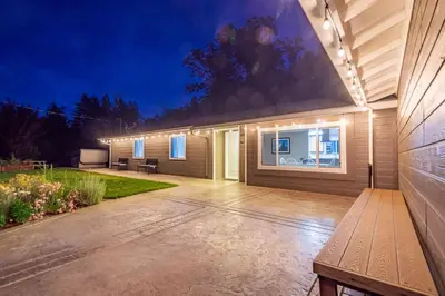 a house with a patio at night with lights at Alpine 4 Bedroom Retreat with Hot tub and Pool table in Coarsegold