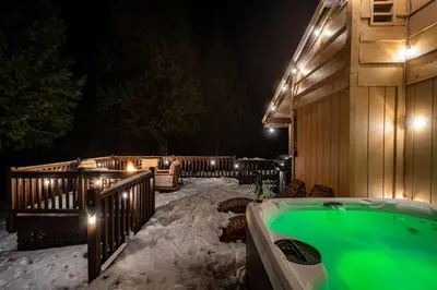 a snowy backyard with a hot tub in the snow at Sugarpine Trailhead Lodge at Lewis Creek Upper Trailhead just 7 miles from Yosemite in Oakhurst