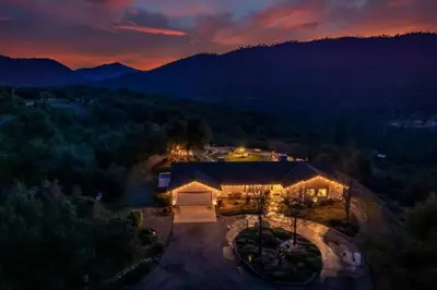 an aerial view of a house in the mountains at night at Fairy Tale 13-acre Sunset Villa at Windy Gap Valley near Yosemite in Ahwahnee
