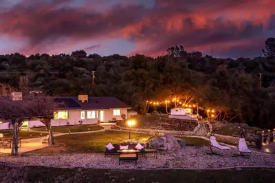 a view of a house with a rainbow in the sky at Fairy Tale 13-acre Sunset Villa at Windy Gap Valley near Yosemite in Ahwahnee