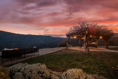 a gazebo with a table and benches in a field at Fairy Tale 13-acre Sunset Villa at Windy Gap Valley near Yosemite in Ahwahnee