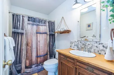a bathroom with a wooden shower curtain and a toilet at Fairy Tale 13-acre Sunset Villa at Windy Gap Valley near Yosemite in Ahwahnee