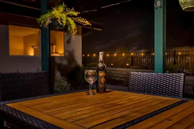 a bottle of wine and a glass on a wooden table at Mystic Mountain Villa, 14 miles from Yosemite in Oakhurst