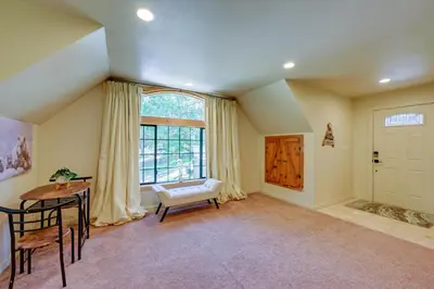 a living room with a table and a window at Lakeside Bear Lodge Studio 9 Mi to Bass Lake! in Bass Lake Annex