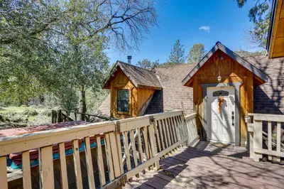 a cabin with a wooden porch and a white door at Lakeside Bear Lodge Studio 9 Mi to Bass Lake! in Bass Lake Annex
