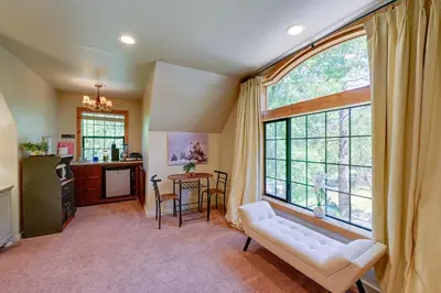 a living room with a white couch and a large window at Lakeside Bear Lodge Studio 9 Mi to Bass Lake! in Bass Lake Annex