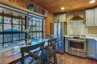 a kitchen with a table and chairs and a stove at 9 Mi to Bass Lake Cabin with Fire Pit in Wishon! in Bass Lake Annex