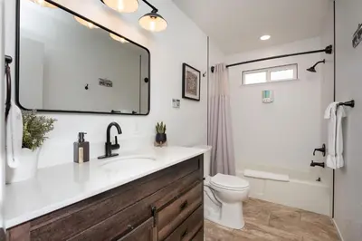 a bathroom with a sink and a toilet and a mirror at Buckeye Bungalow w hot tub/firepit/views Pet Friendly in Oakhurst