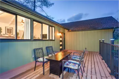 a wooden table and chairs on a deck at Buckeye Bungalow w hot tub/firepit/views Pet Friendly in Oakhurst
