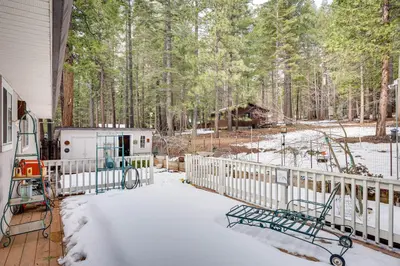 a snow covered porch with a fence and trees at Renovated Pioneer Home in Serene Wooded Setting! in Pioneer