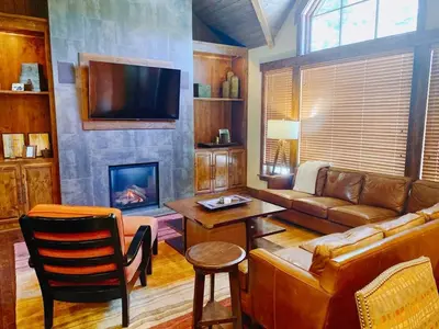 a living room with a couch and a fireplace at Luxury Northstar Home| hot tub| walk to ski lifts in Truckee