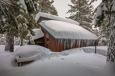 a house covered in snow in front of a cabin at North Lake Tahoe Cabin and Hot Tub in Tahoe City