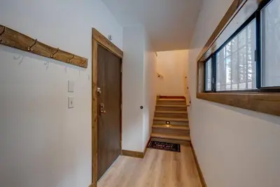 a hallway with a wooden door and stairs with a window at Extra Spacious 2BR Cabin w Office and Outdoor Deck in Incline Village