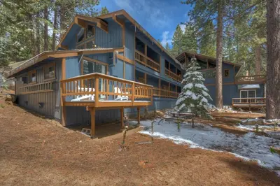 a large house with a large deck in the woods at Extra Spacious 2BR Cabin w Office and Outdoor Deck in Incline Village