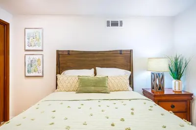 a bedroom with a large bed with a wooden headboard at Red Rock Falls Cabin, 8 miles from Yosemite South Gate, with trailhead, Game Room and HotTub in Oakhurst
