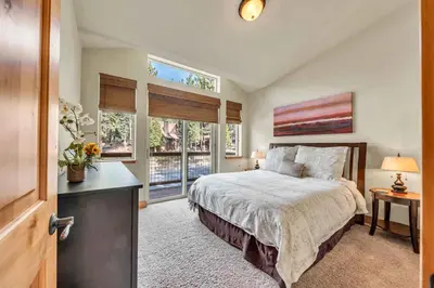 a bedroom with a bed and two windows at Sunny Daze Cabin Luxurious 4BDR with Stunning Views in Kings Beach