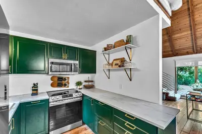 a green kitchen with white walls and wooden cabinets at The Rigi Chalet HOA Beach Access Close to town in Tahoe City