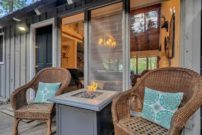 a porch with two chairs and a table with candles on it at The Rigi Chalet HOA Beach Access Close to town in Tahoe City