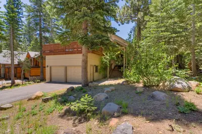 a house with a garage in the woods at Modern 3BR Tahoe Cabin with Hot Tub in Tahoe City