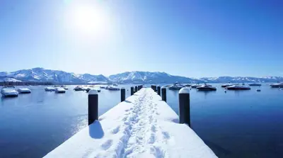 a dock covered in snow with boats in the water at Modern 3BR Tahoe Cabin with Hot Tub in Tahoe City