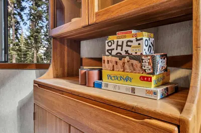 a stack of books sitting on a wooden shelf at Talmont Pines 4BR Retreat with HOA Beach Access in Tahoe City
