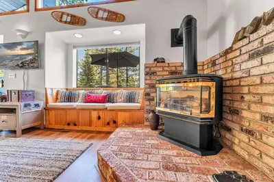 a living room with a brick fireplace and a couch at The Big Bear Chalet Private Hot Tub in Carnelian Bay