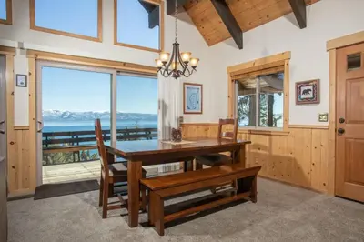 a dining room with a table and chairs and a large window at Carnelian Bay View Cabin in Carnelian Bay