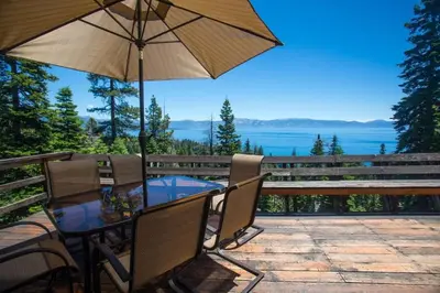 a table and chairs with an umbrella on a patio at Carnelian Bay View Cabin in Carnelian Bay