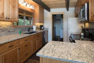 a kitchen with wooden cabinets and a granite counter top at Carnelian Bay View Cabin in Carnelian Bay
