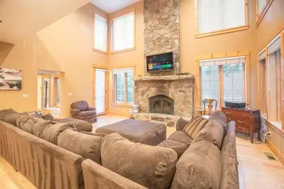 a large living room with couches and a stone fireplace at The Tallac Lodge Hot Tub Walk 2 Beach in Carnelian Bay