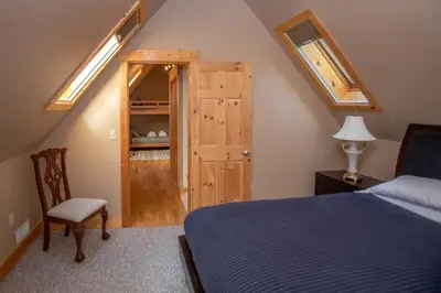 a bedroom with a blue bed and a wooden door at The Tallac Lodge Hot Tub Walk 2 Beach in Carnelian Bay