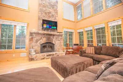 a living room with couches and a stone fireplace at The Tallac Lodge Hot Tub Walk 2 Beach in Carnelian Bay